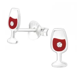 Zilveren oorstekers, wijnglas met rode wijn en kristal
